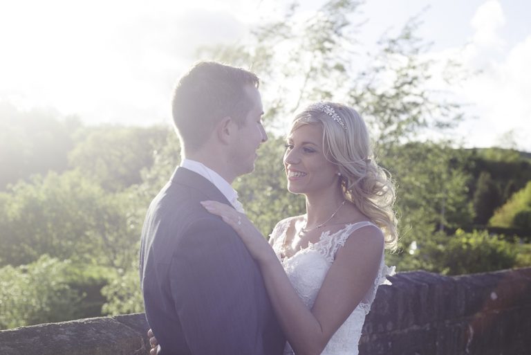 Bride and groom embracing on a sunny day in the countryside