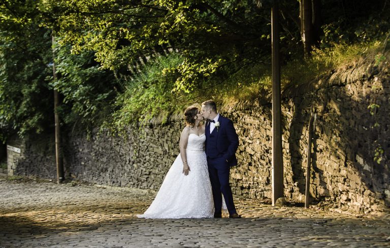 Bride and groom embrace in scenic outdoor wedding setting
