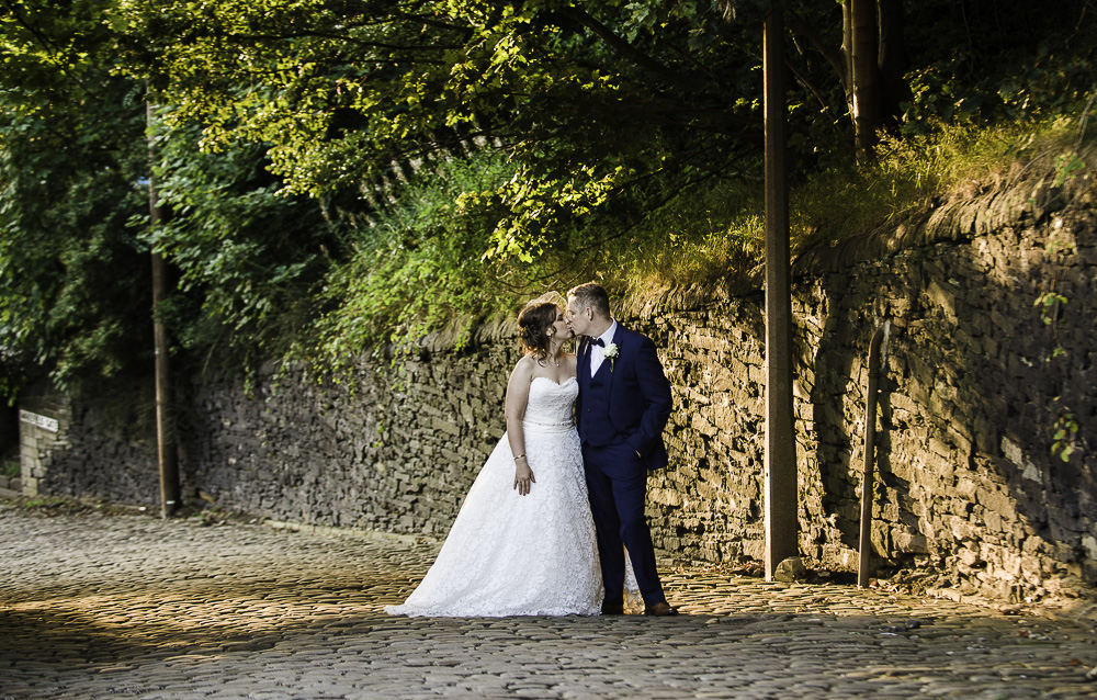 Bride and groom embrace in scenic outdoor wedding setting