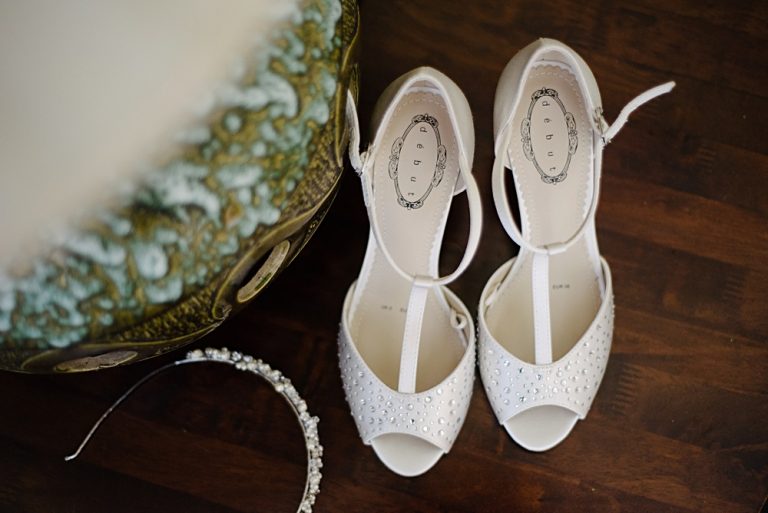Elegant bridal shoes and headband on wooden floor