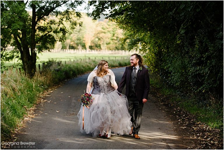 Bride and groom walking on a scenic country road