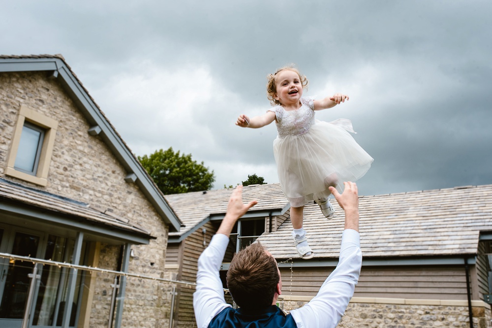 Father joyfully lifts daughter outside family home