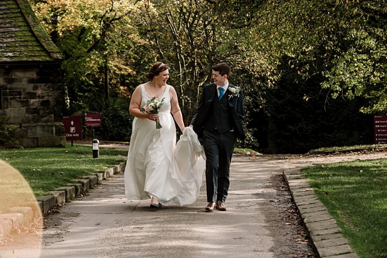 Bride and groom walking in a park on their wedding day