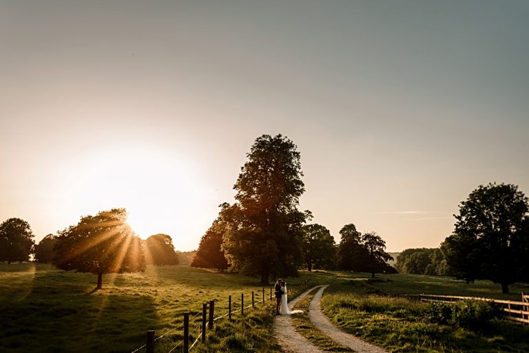 Sunset over scenic countryside path with lush green trees