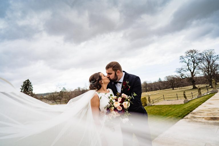 Bride and groom kissing in scenic outdoor wedding scene