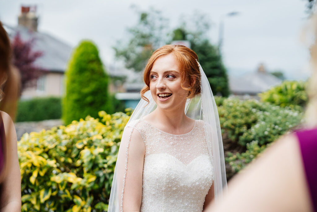 Bride smiling in garden setting on her wedding day