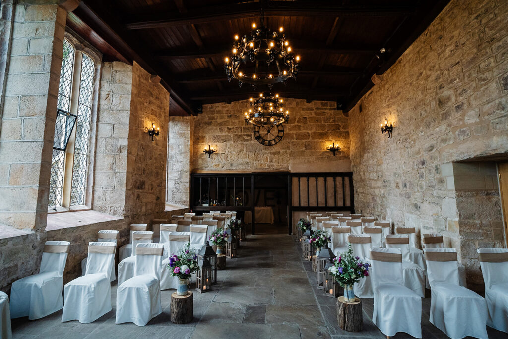 Rustic wedding ceremony setup in an elegant stone hall at The Priests House in Barden, North Yorkshire