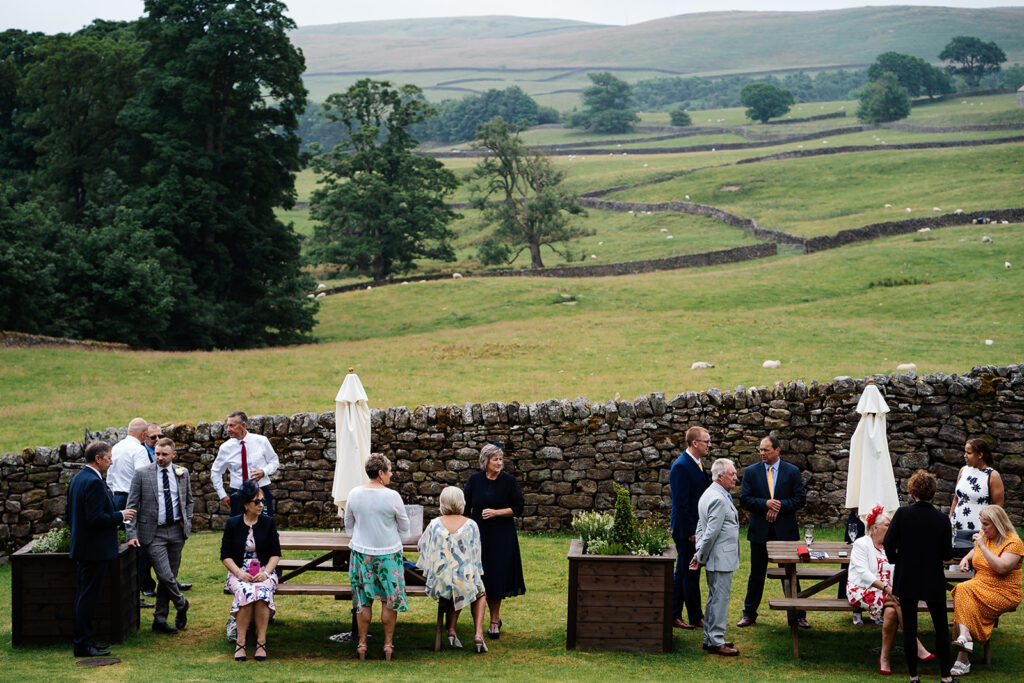 People at outdoor gathering with scenic countryside background The Priests House in Barden, North Yorkshire