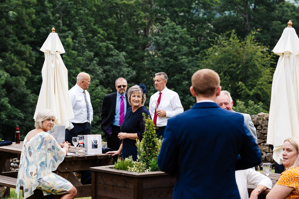 Guests enjoying an outdoor social gathering in a garden setting The Priests House in Barden, North Yorkshire