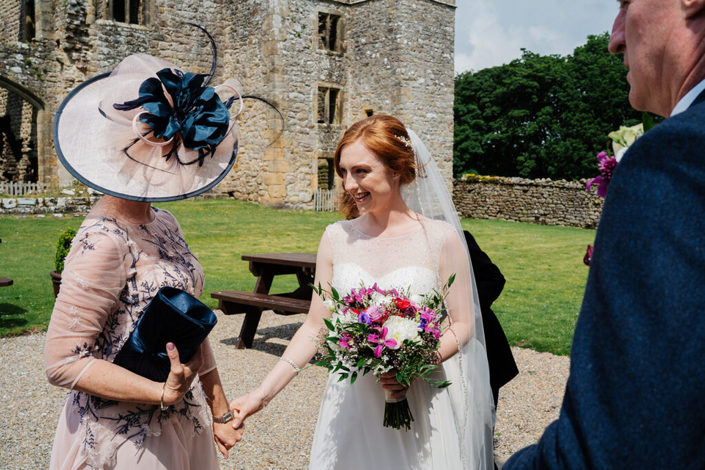 Bride greeting guest at outdoor wedding ceremony The Priests House in Barden, North Yorkshire