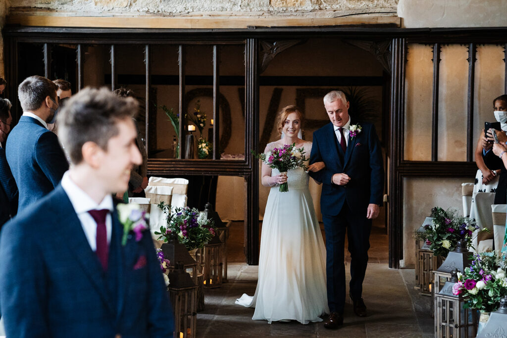 Bride walking down the aisle with father at wedding ceremony The Priests House in Barden, North Yorkshire