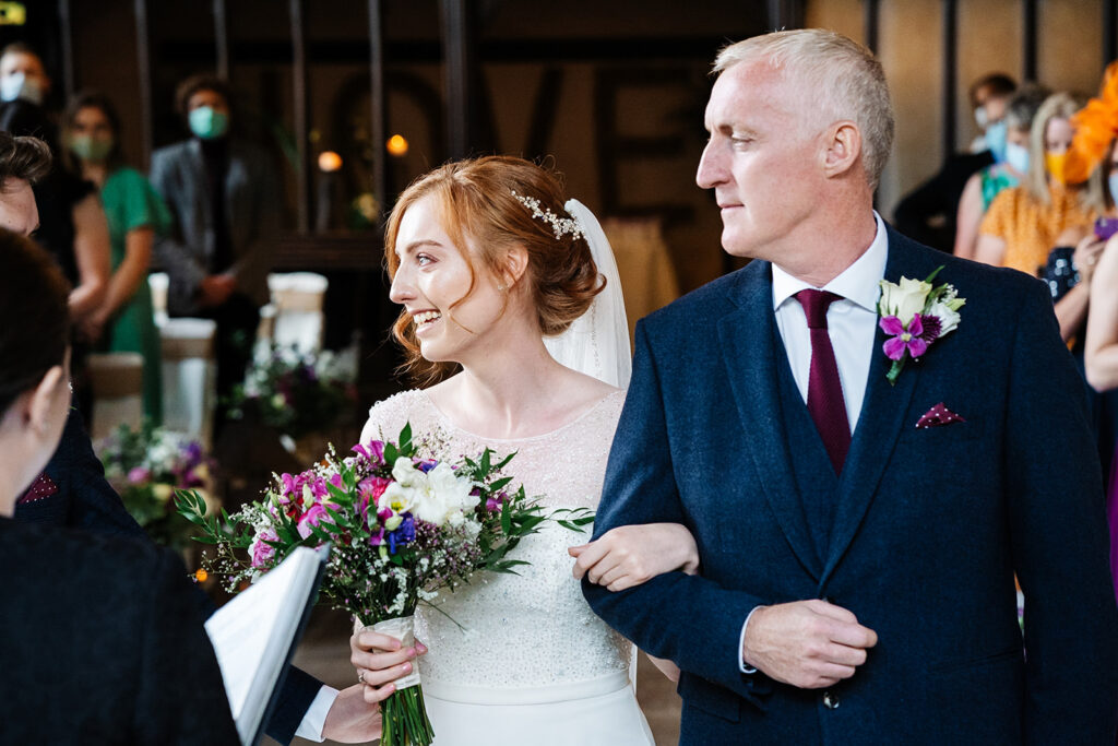 Bride walking down the aisle with her father holding a bouquet The Priests House in Barden, North Yorkshire