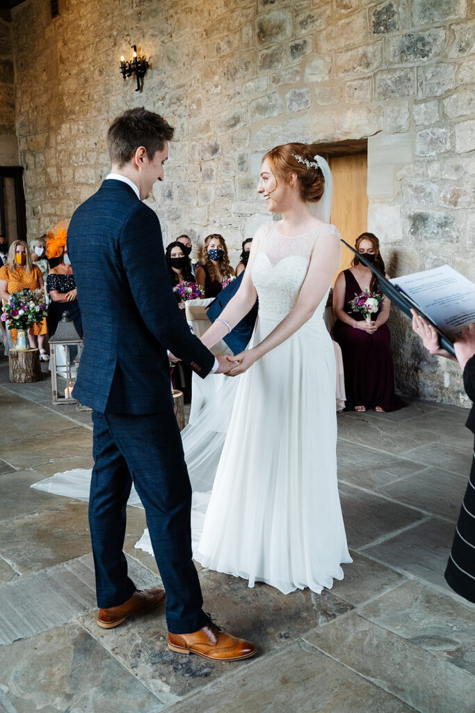 Bride and groom exchanging vows in a stone chapel ceremony The Priests House in Barden, North Yorkshire