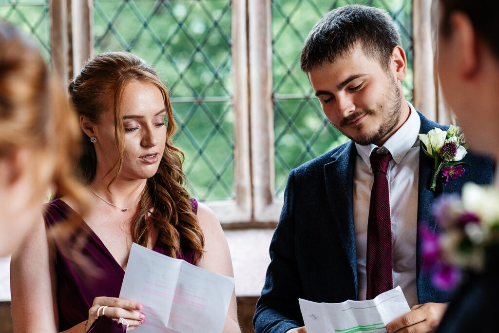 A couple reading scripts at a wedding ceremony in a church
