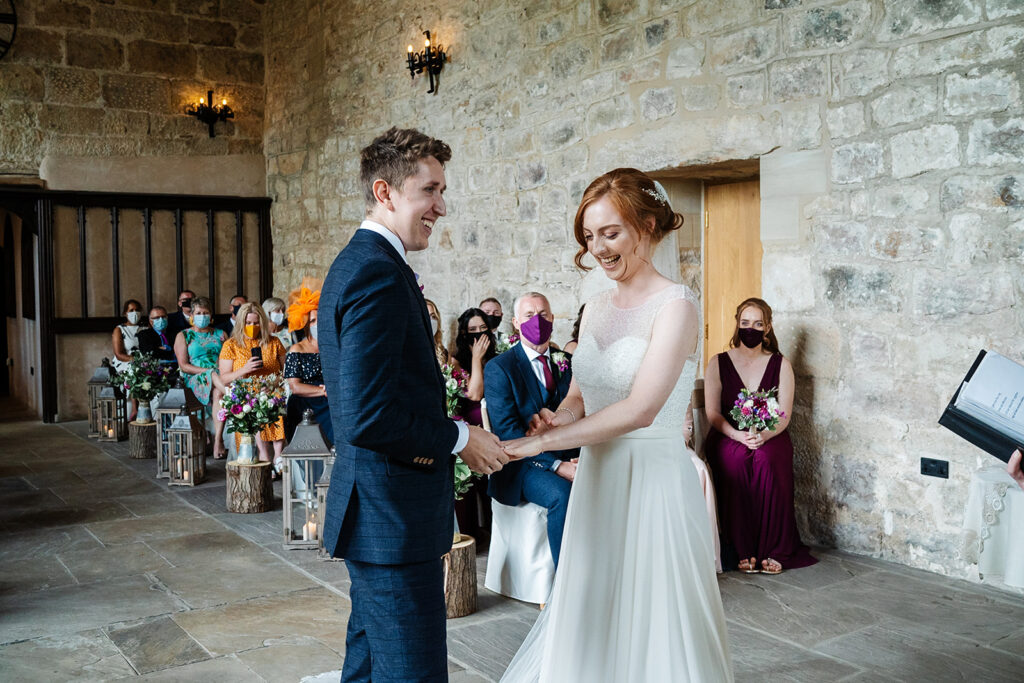 Bride and groom exchanging vows in rustic wedding ceremony The Priests House in Barden, North Yorkshire