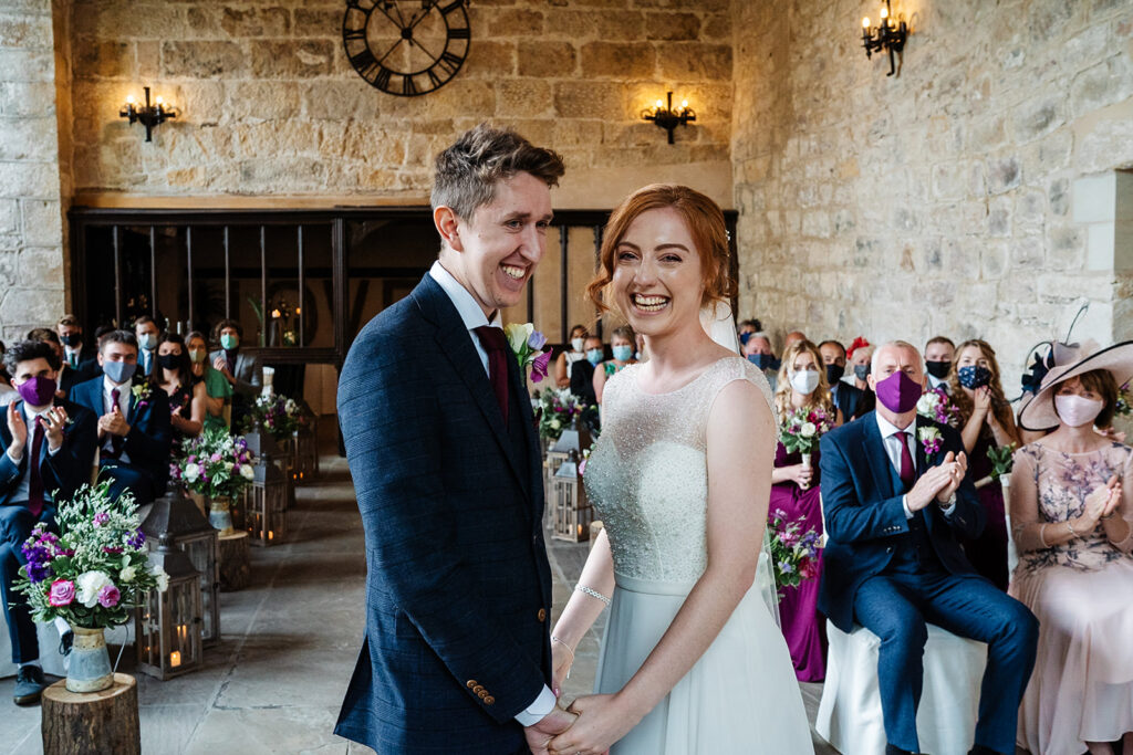 Bride and groom smiling during intimate indoor wedding ceremony The Priests House in Barden, North Yorkshire