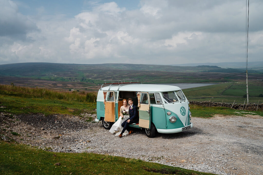 Vintage van with couple in scenic countryside setting.