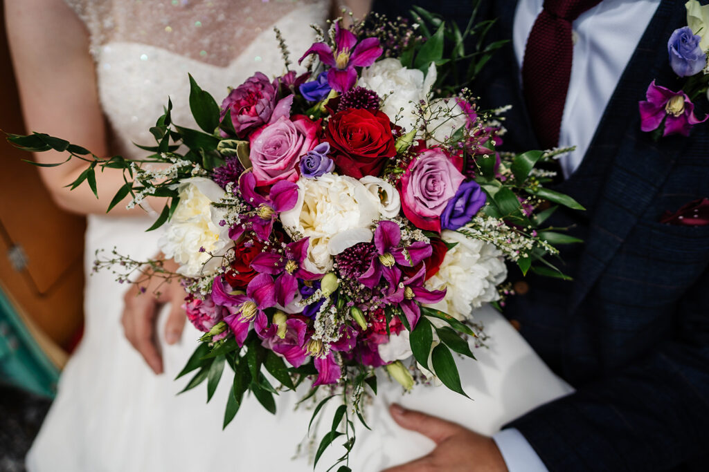 Bride holding vibrant bouquet at wedding ceremony close-up