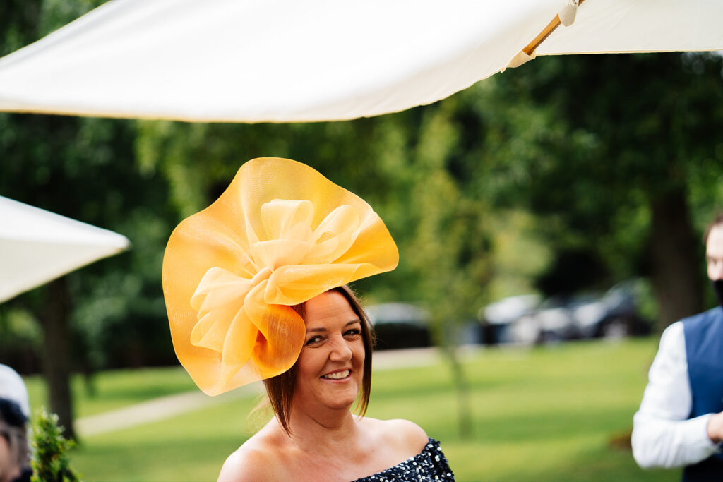 Woman wearing an elegant orange hat at outdoor event