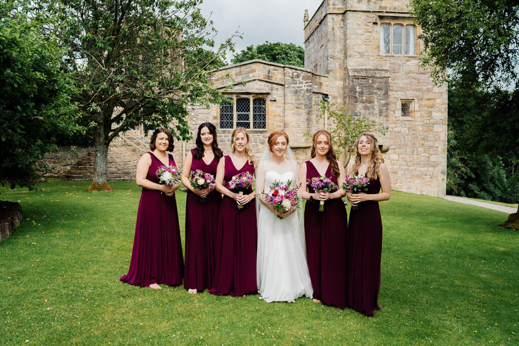 Bridal party posing in garden at historic wedding venue