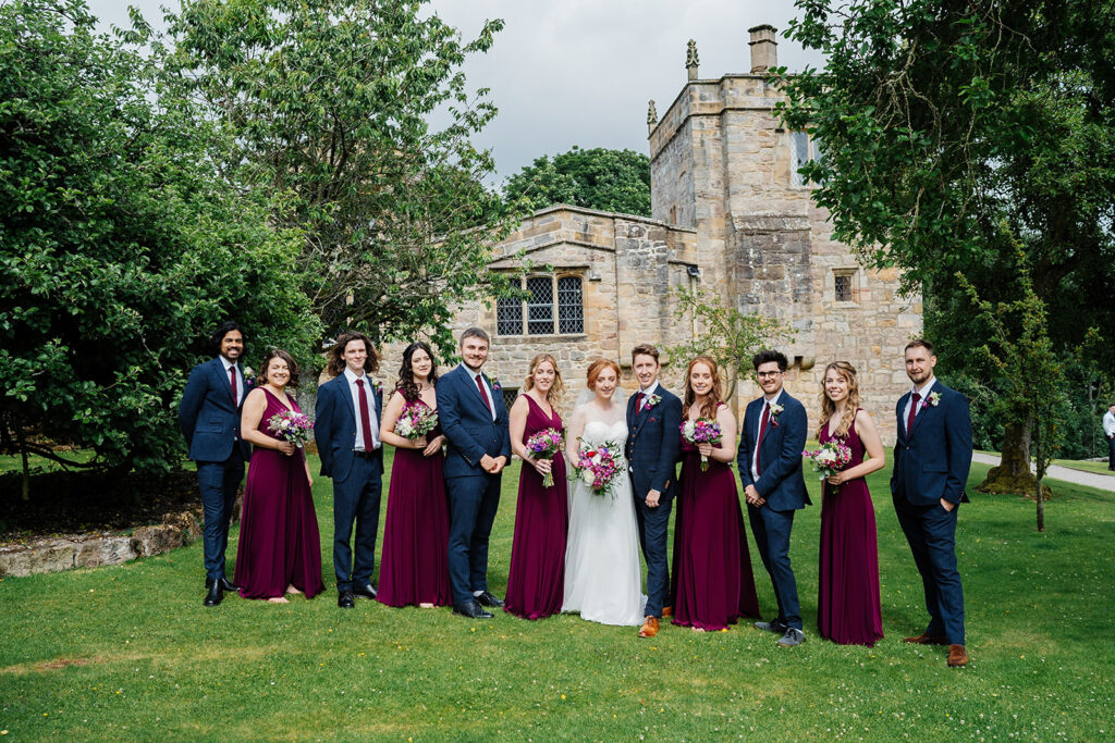 Wedding party posing at a historic venue in scenic surroundings