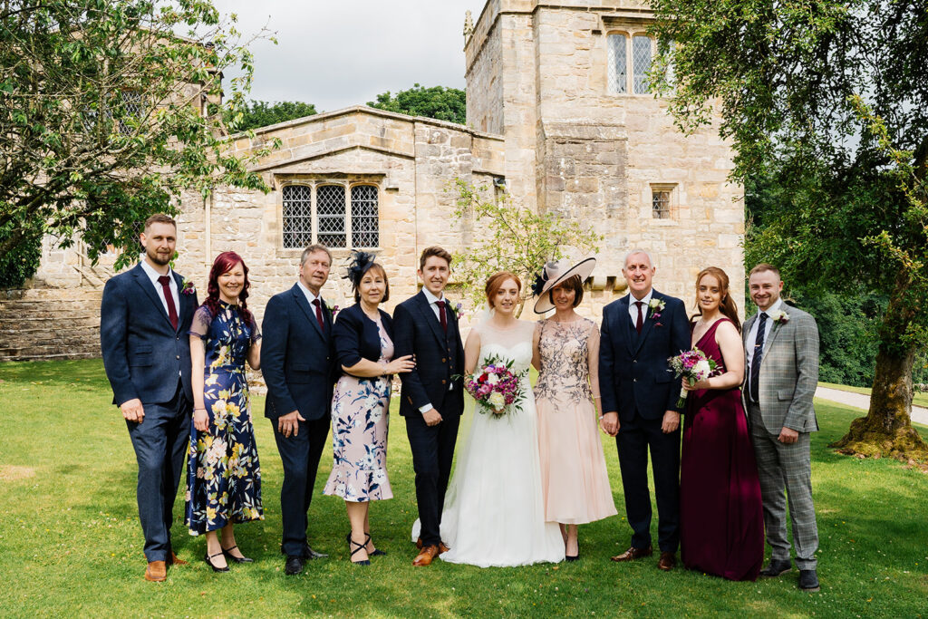 Group celebrating at outdoor wedding by historic building
