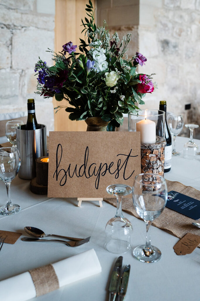Elegant wedding table decor with Budapest sign and flowers.