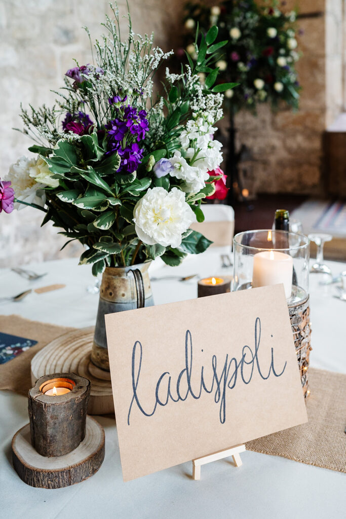 Wedding table decor with flowers and a candlelit sign