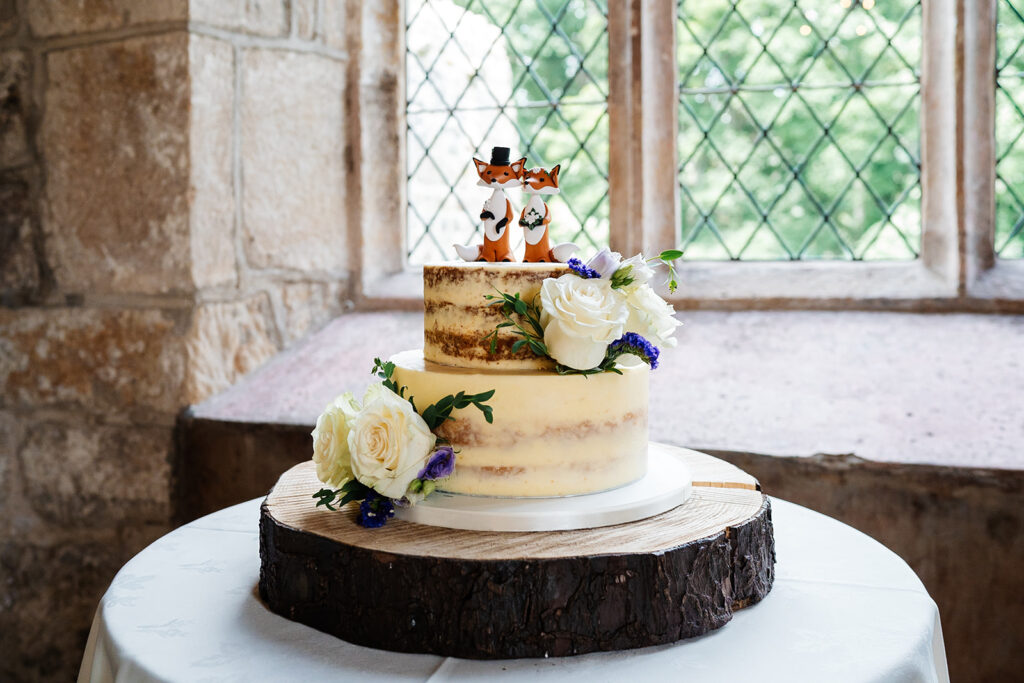 Rustic wedding cake with flower decorations on wooden stand