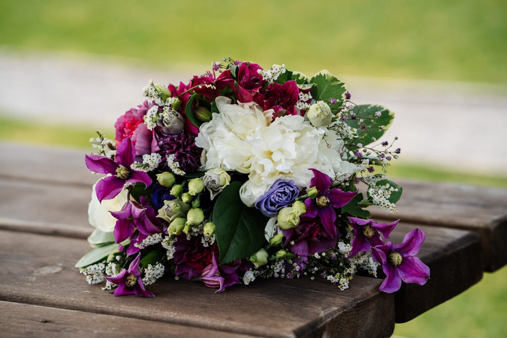 Vibrant floral bouquet on rustic wooden table outdoors