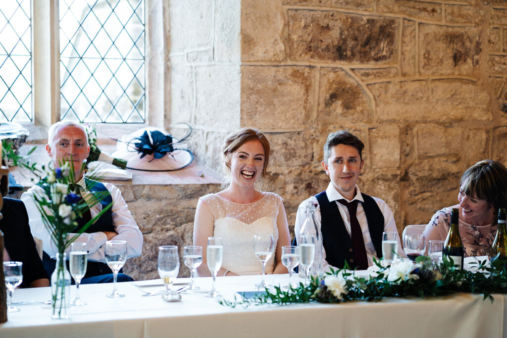 Bride and guests seated at a rustic wedding reception table