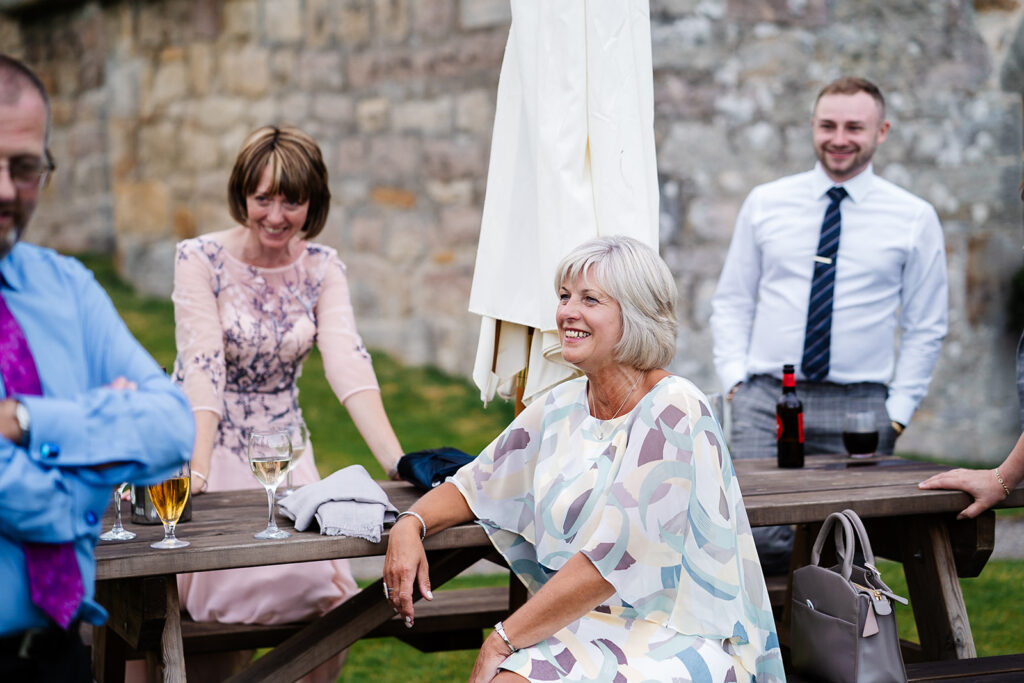 Group enjoying a social event outdoors at a wooden table