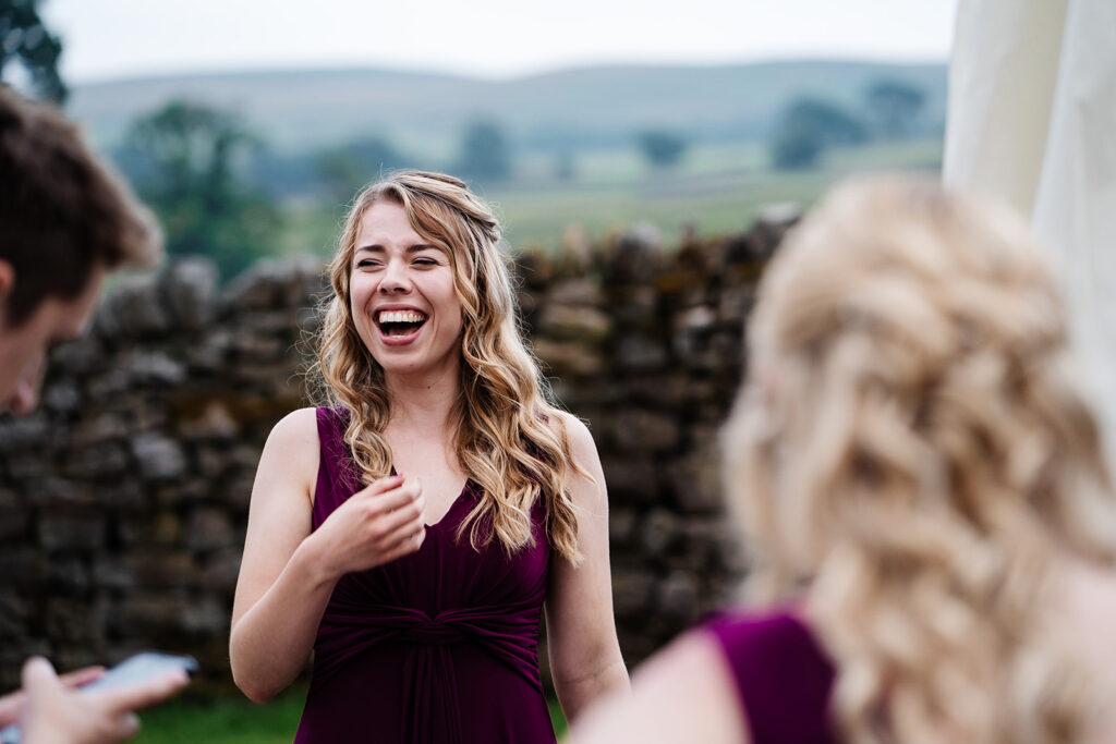 Woman in purple dress laughing at outdoor event