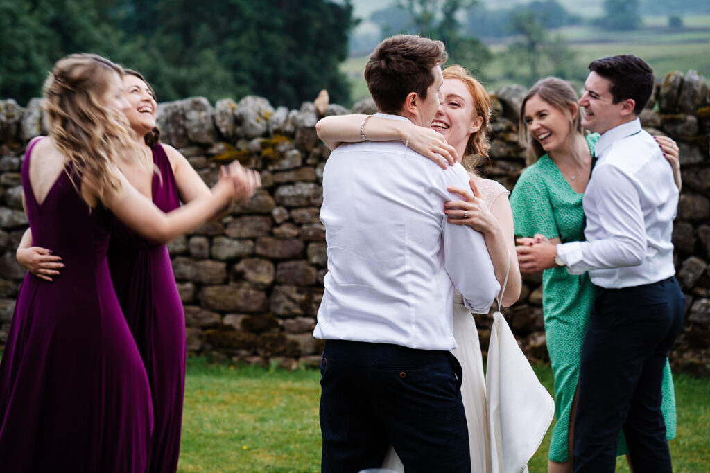 People dancing joyfully outdoors at a wedding reception