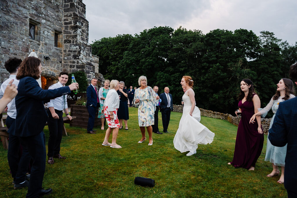 People celebrating outside a castle in festive attire