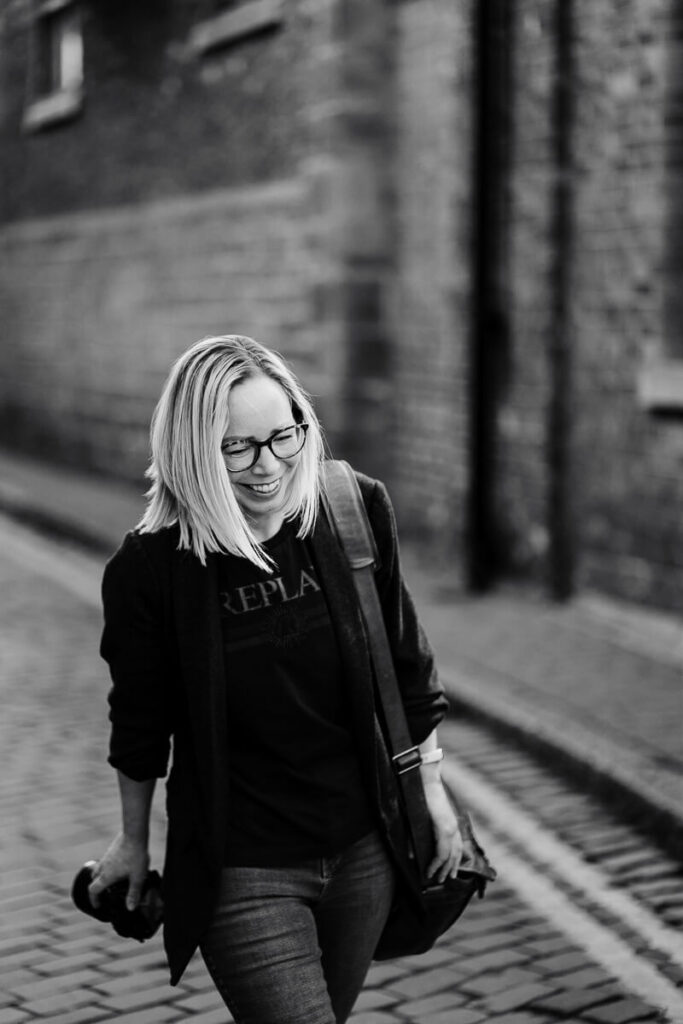 Woman walking down cobblestone street in black and white photo