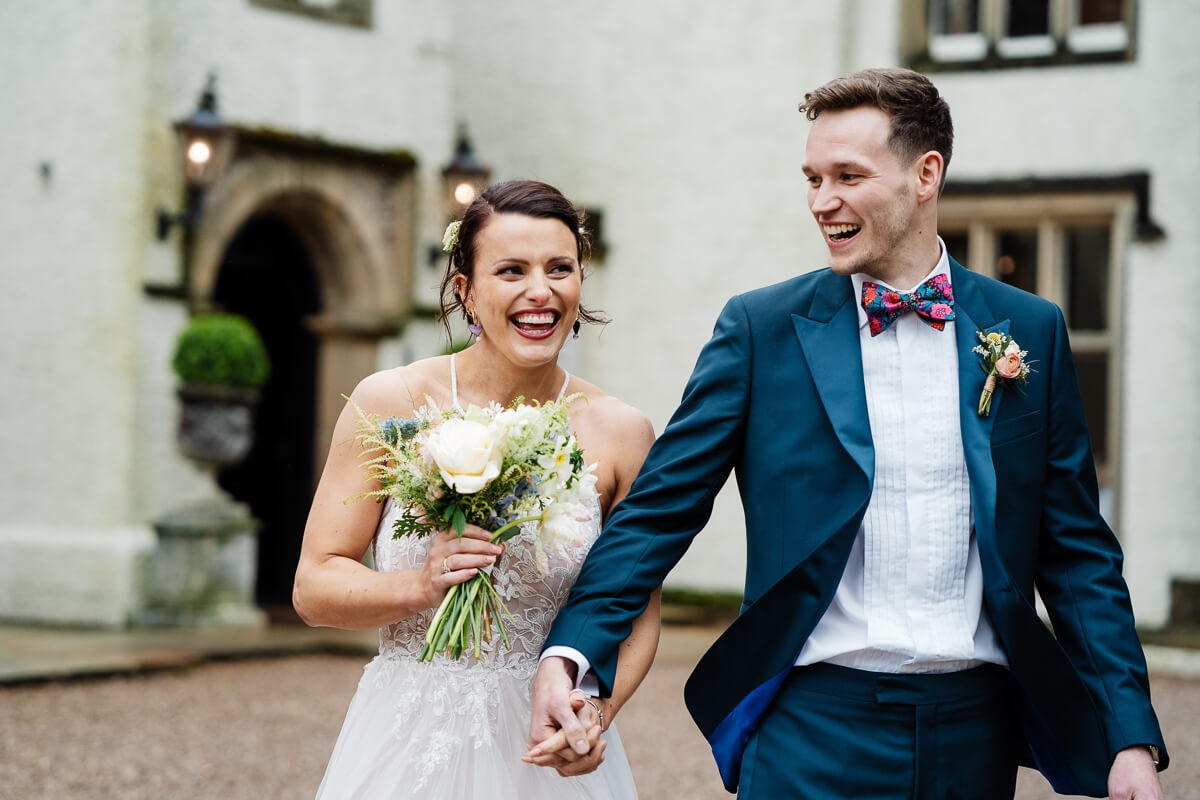 Bride and groom smiling at an elegant outdoor wedding venue