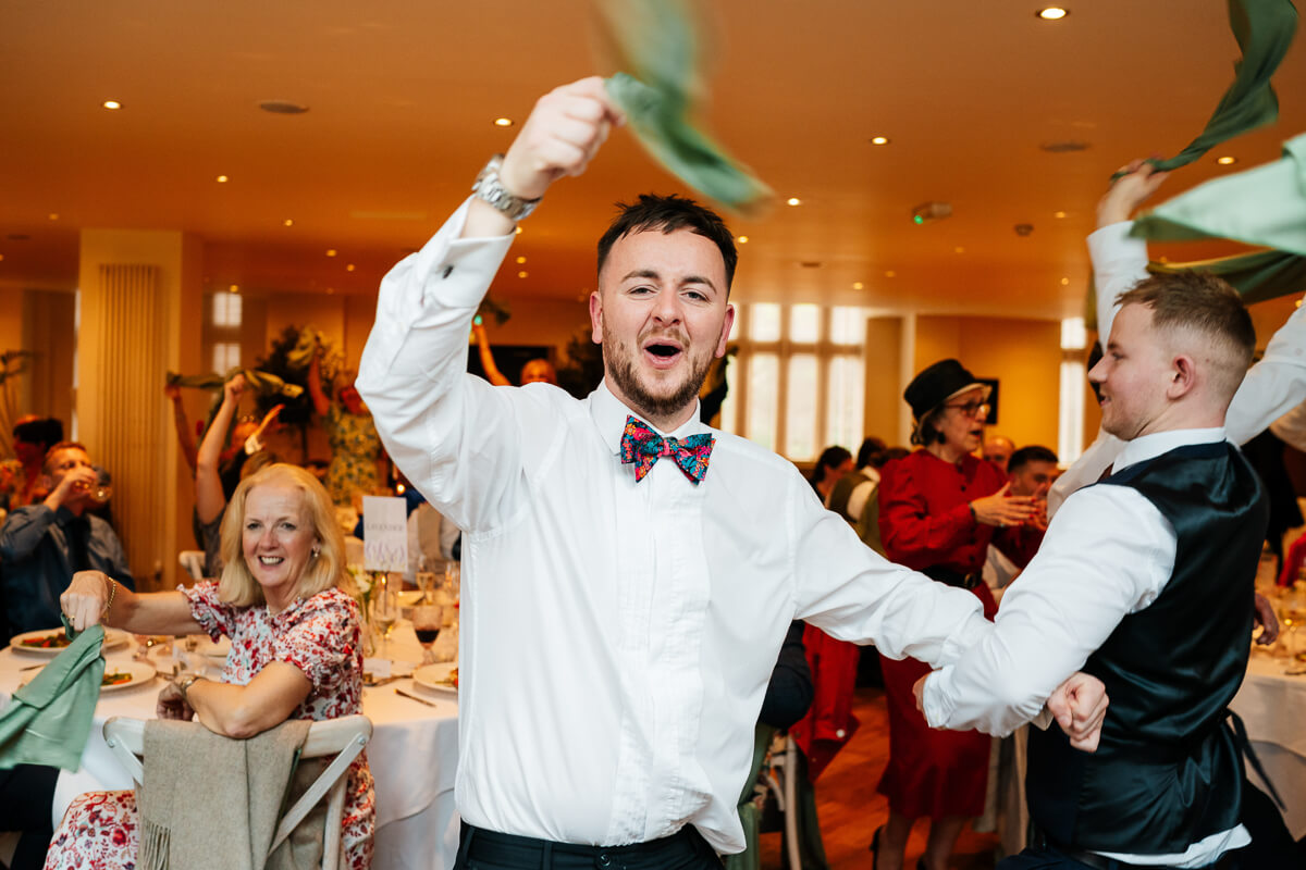 Man celebrating at joyful wedding reception party