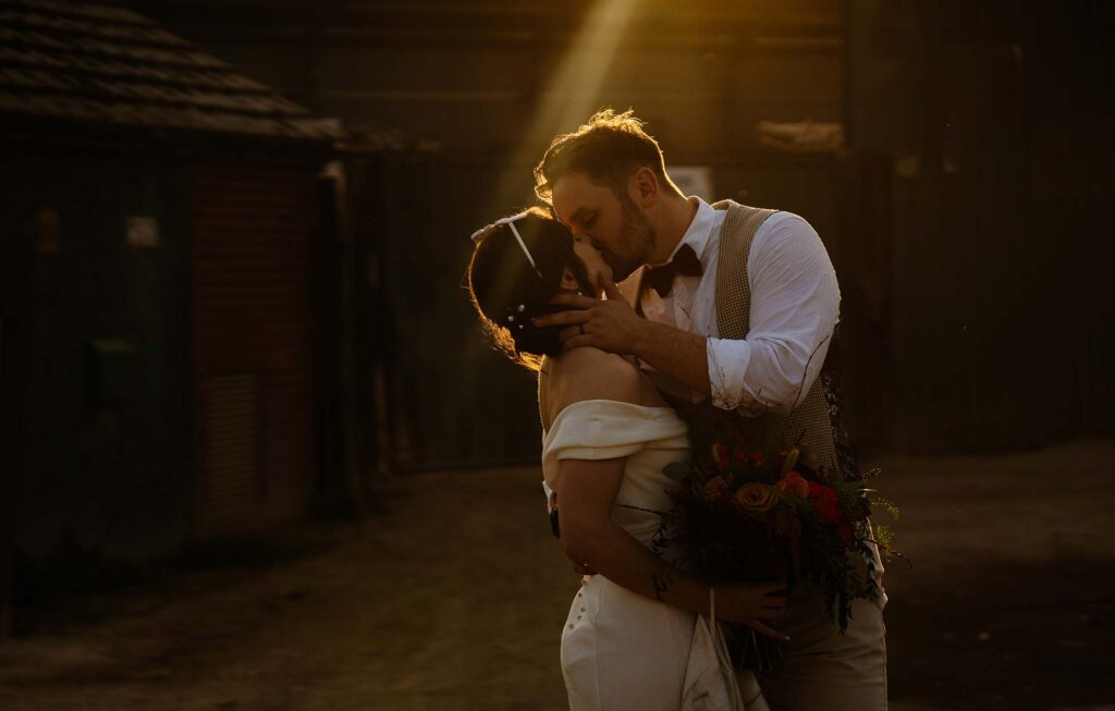 Romantic couple kissing at sunset on their wedding day