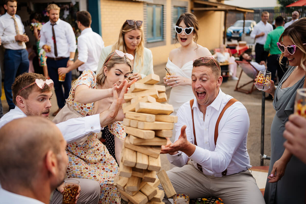 Group enjoying outdoor Jenga game at festive gathering