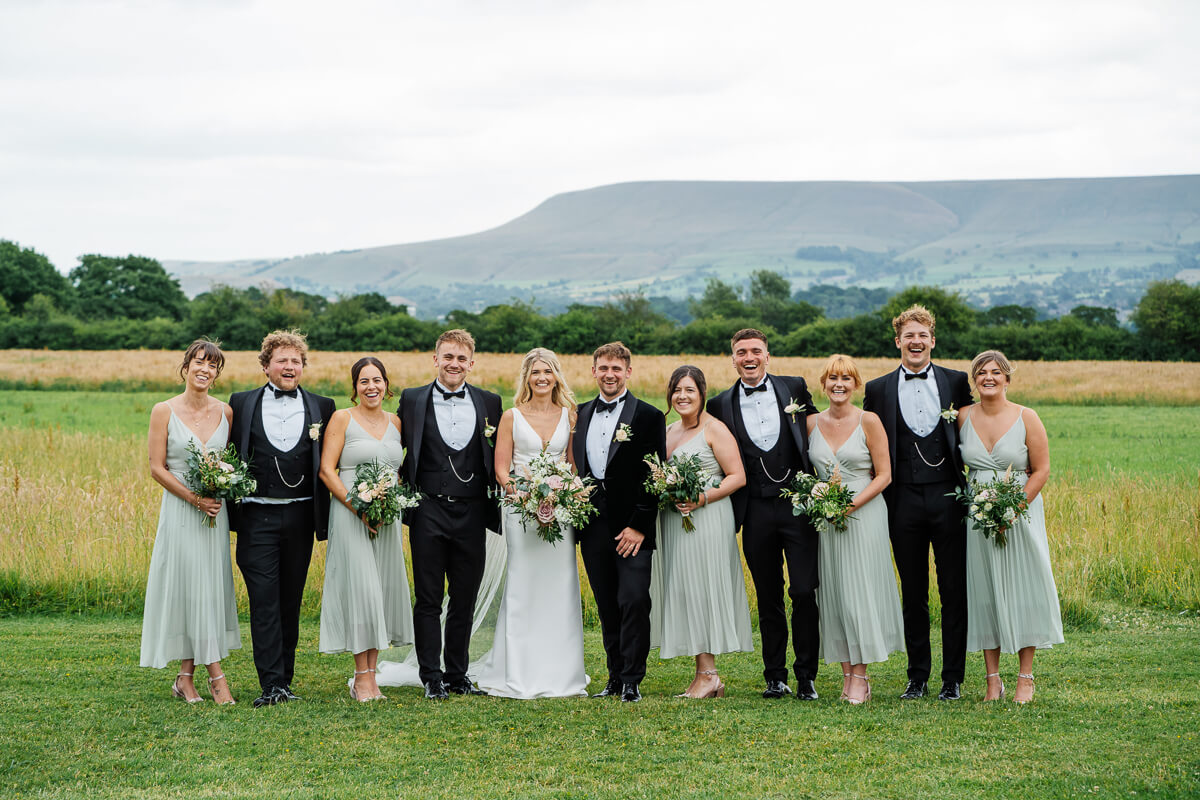Wedding party posing in scenic countryside background
