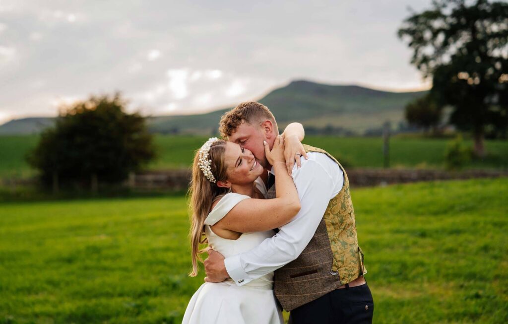 Bride and groom embracing in scenic outdoor setting