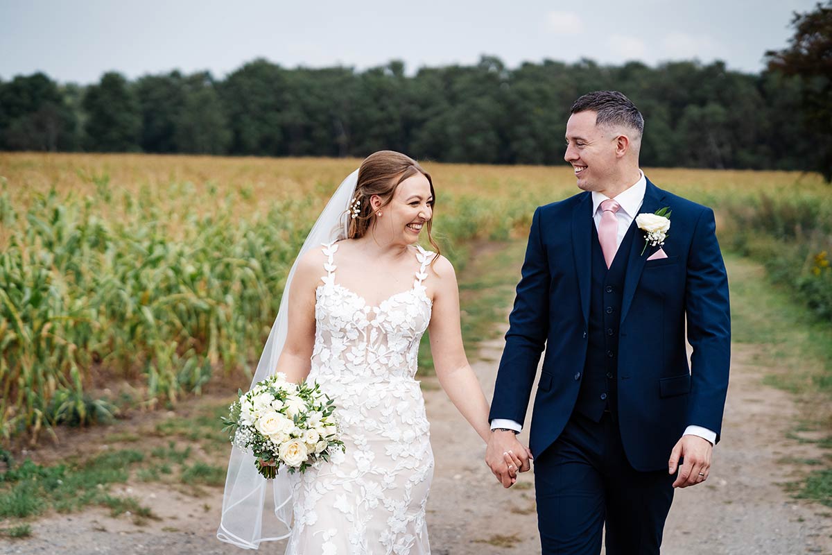 Bride and groom smiling in countryside wedding setting