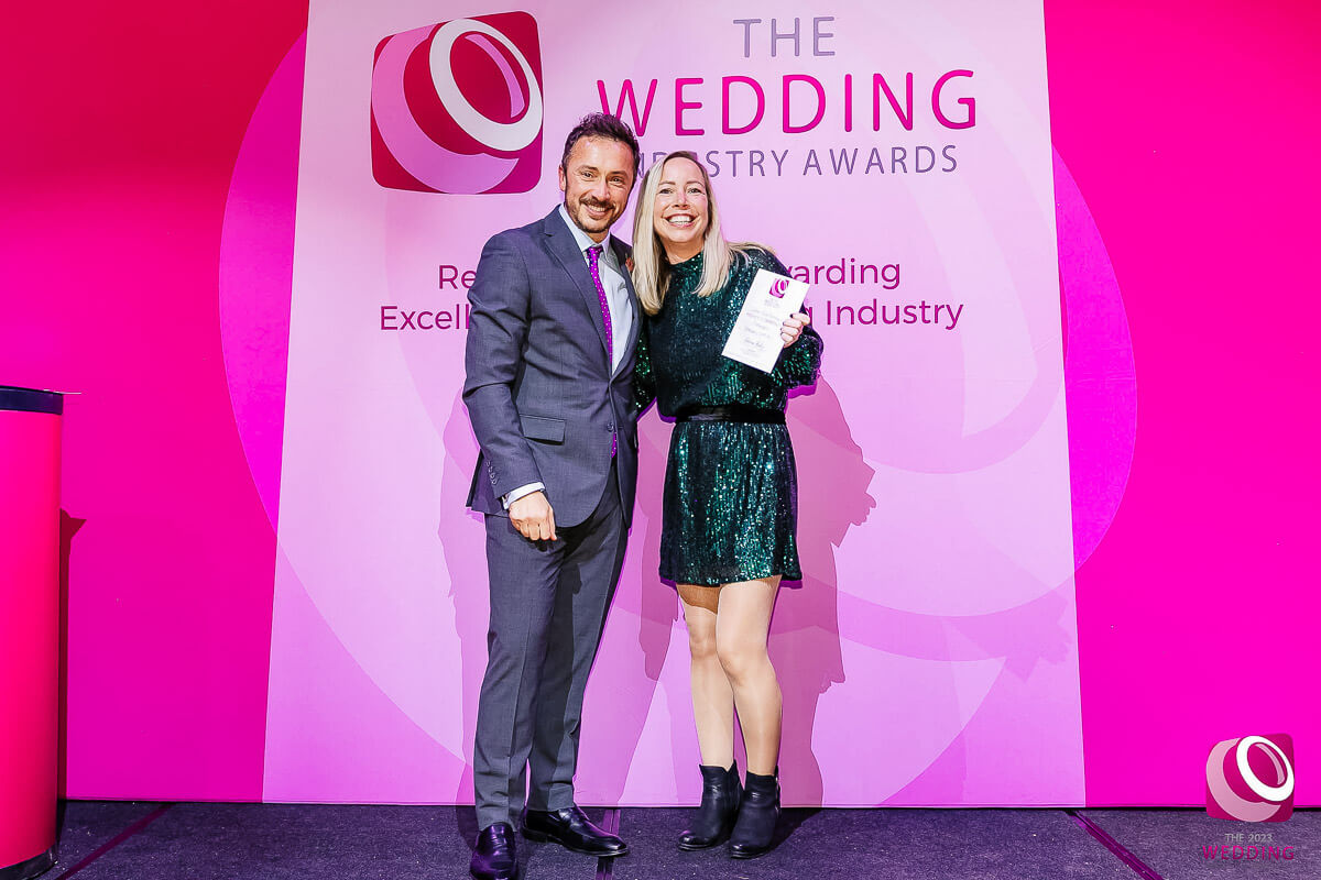 Two people holding an award at wedding industry event